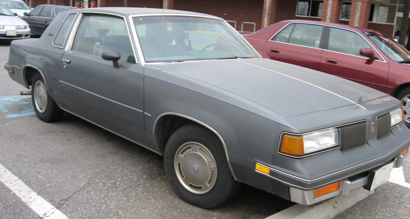 Gray 1987 Oldsmobile Cutlass Supreme coupe parked outdoors.